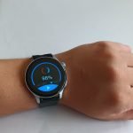 Smartwatch GT5 mostrando su pantalla de 240x240 píxeles y diseño elegante con correa negra de silicona.