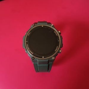 Smartwatch Q70 Pro, de color verde de fondo rojo, mostrando su diseño y su estilo.